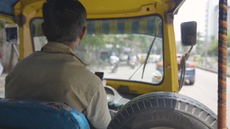 Vista dal passeggero di un uomo che guida un autorisciò lungo una strada a Bangalore, India 1