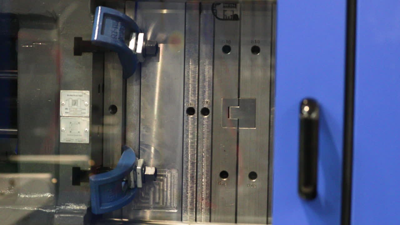 공장에서 플라스틱 제품을 생산하는 직장에서 사출 성형 기계를 닫습니다.