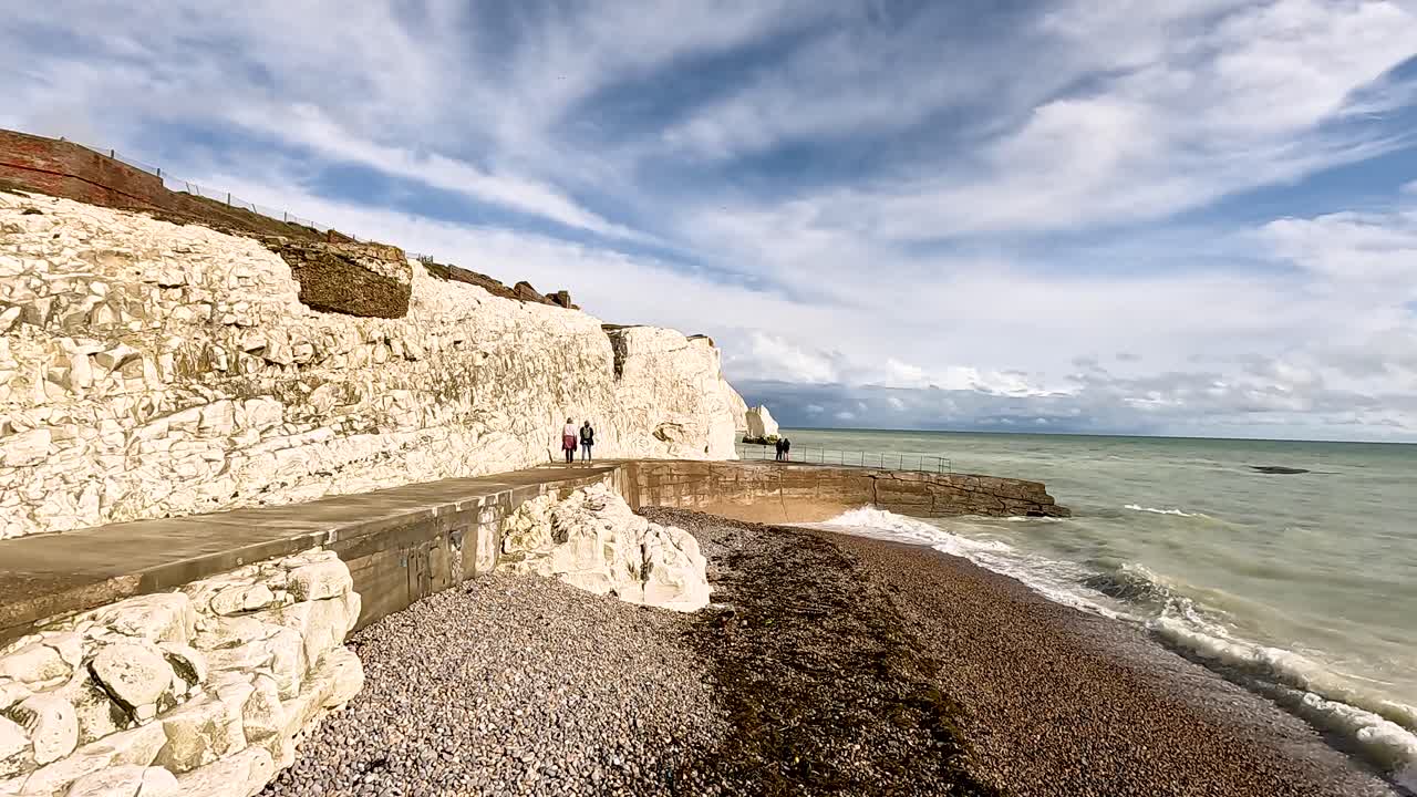 gente caminando por acantilados y mar