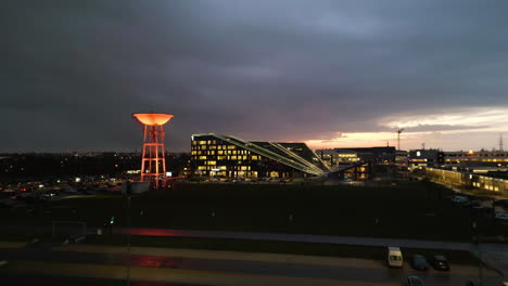 Eine-Drohne-Fliegt-Nachts-über-Die-Beleuchteten-Gebäude-Auf-Dem-Corda-Campus-In-Hasselt,-Belgien