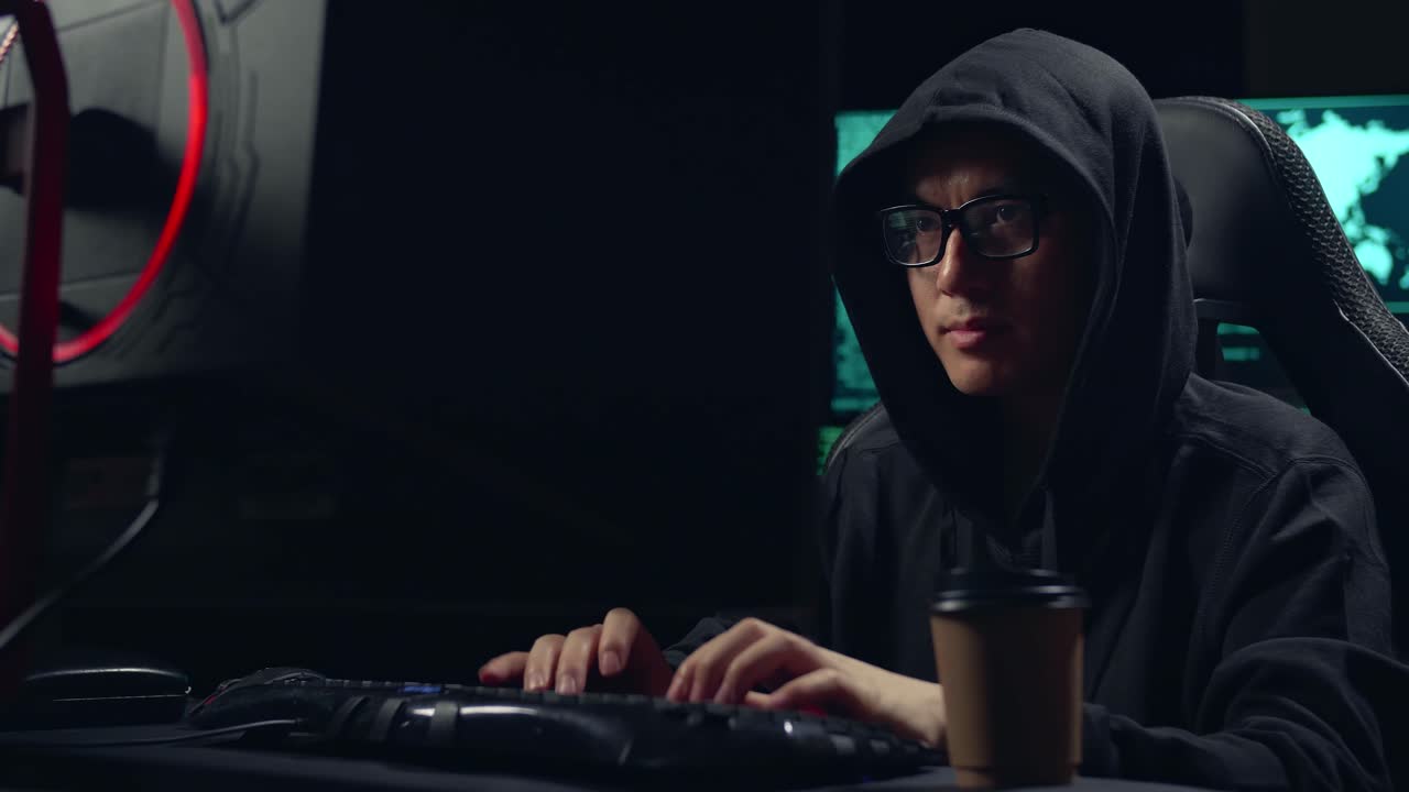 Asian Male Hacker Using Computer Hacking