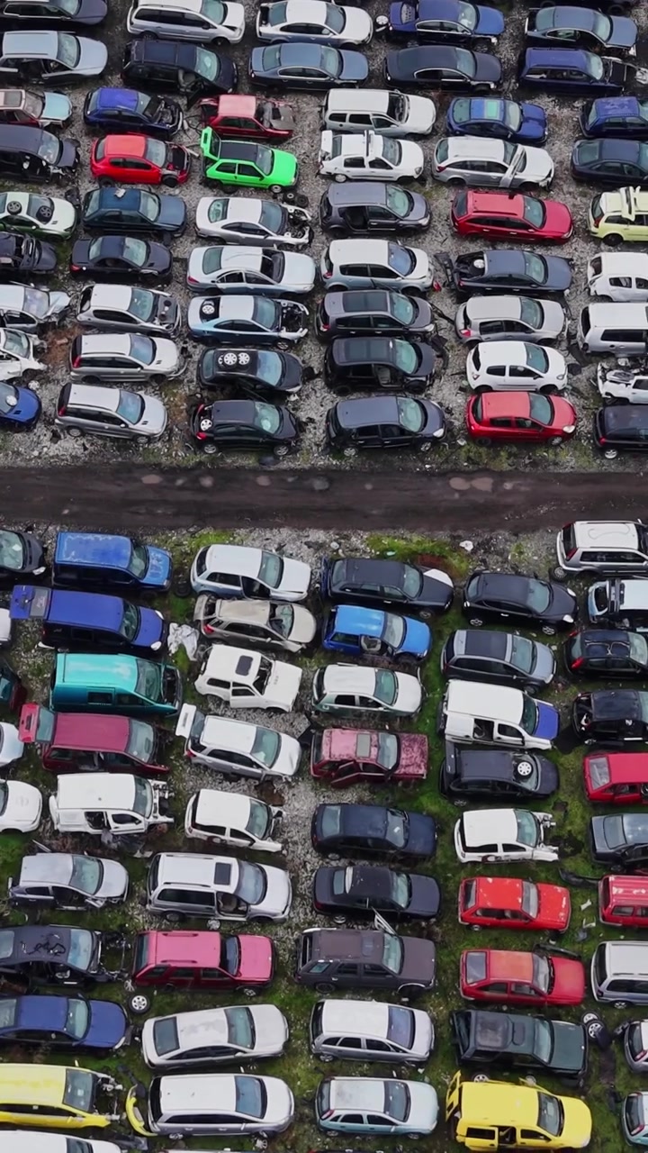 Biler parkeret på et stort område på en losseplads i dagslys