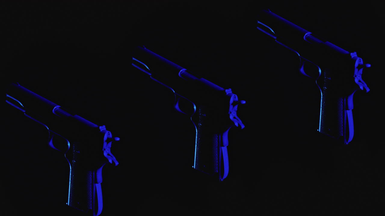 Pistols on the dark background and in blinking red and blue light rotate in slowmotion