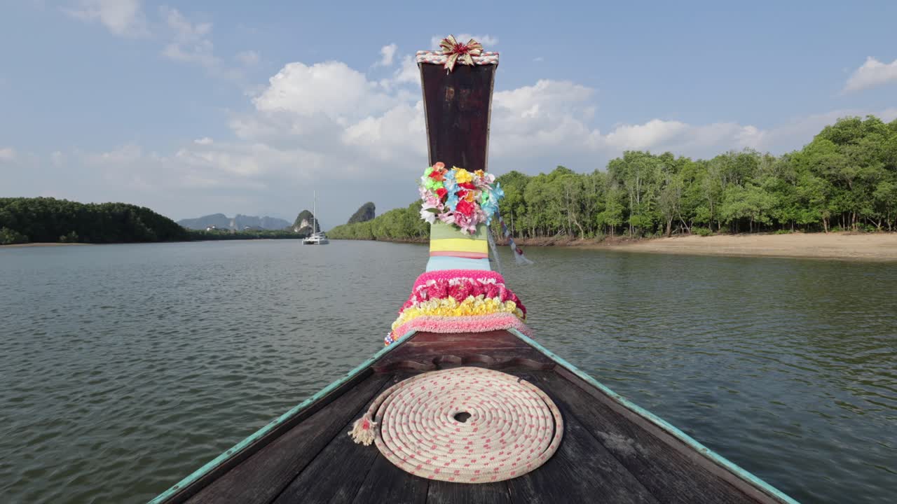 크라비 타운 태국 양쪽에 숲이 있는 하얀 모래 해변과 거리에 있는 카타마란과 함께 일몰 동안 강을 따라 달리는 화려한 꽃으로 장식된 나무 태국 롱테일 보트