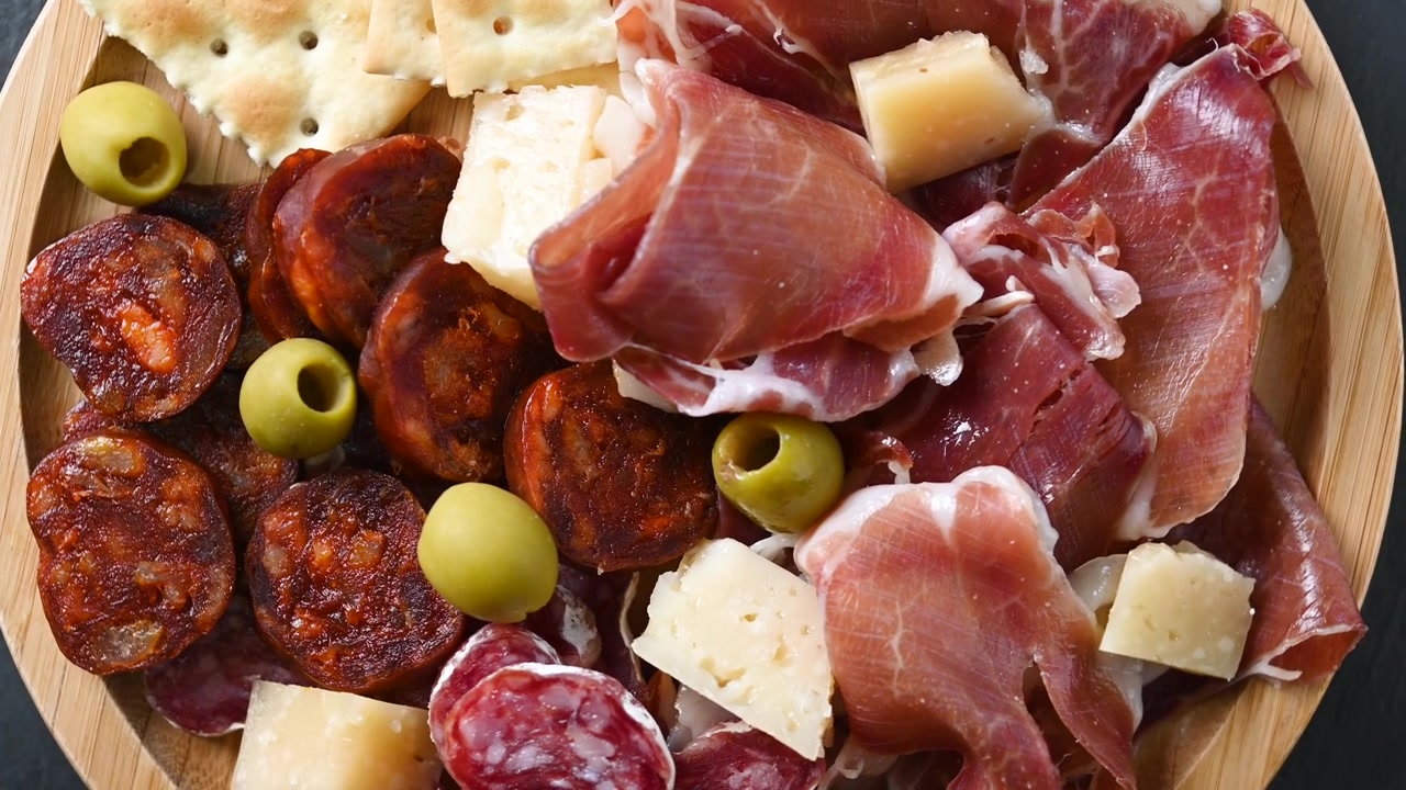 Planche de charcuterie espagnole avec viandes séchées et fromage en rotation