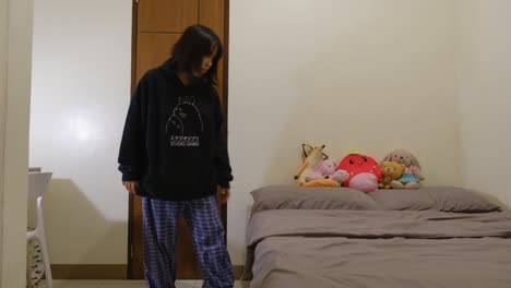 tired asian girl walks into bedroom and shuts door