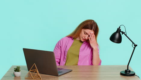 adult woman sitting at table looking upset and irritated after system crash or file loss on laptop
