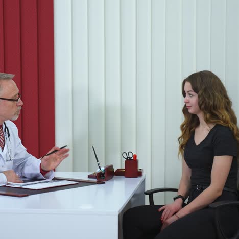 female patient is sitting at doctor`s office. cute patient is listening carefully to medic`s advi?e. modern clinic background
