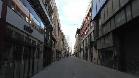 rue neuve, brussels, belgium. april third 2020. corona virus lockdown, walking along empty famous shopping street. ghost town. forward tracking shot.