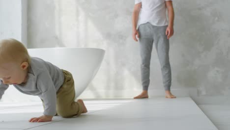 Adorable-Baby-Boy-With-Blonde-Hair-Crawling-On-Bathroom-Floor-And-Giggling