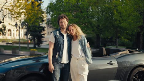 A-cute-loving-couple-of-a-guy-and-a-girl-in-denim-jackets-are-standing-posing-and-looking-at-the-camera-against-the-background