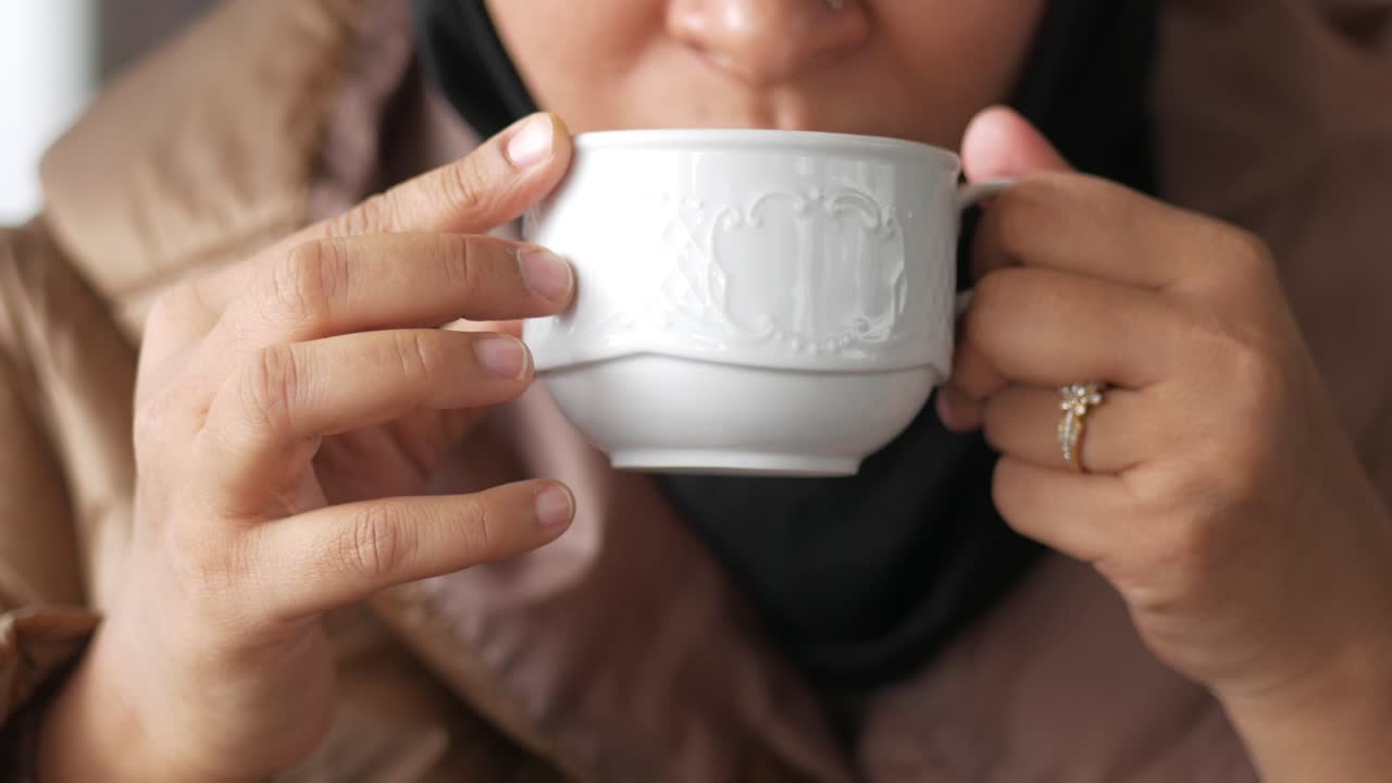 close up de la mano de las mujeres sosteniendo una taza de café