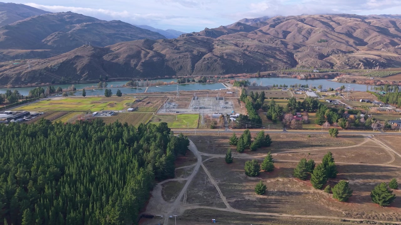 Riprese aeree con drone della centrale elettrica di Cromwell, del fiume Clutha e delle colline circostanti, che mostrano l'infrastruttura energetica e il paesaggio suggestivo del Central Otago.