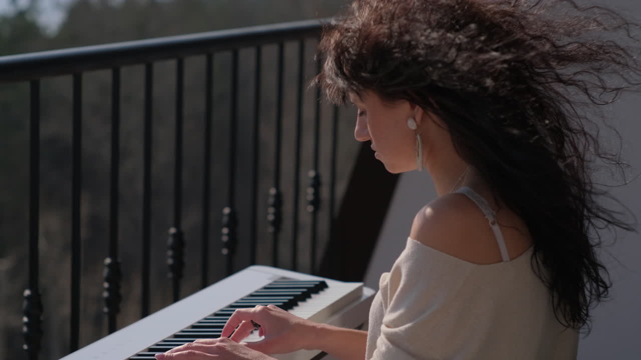mujer tocando el piano en un balcón