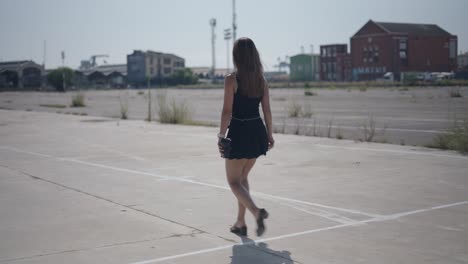 woman walking in empty urban parking lot