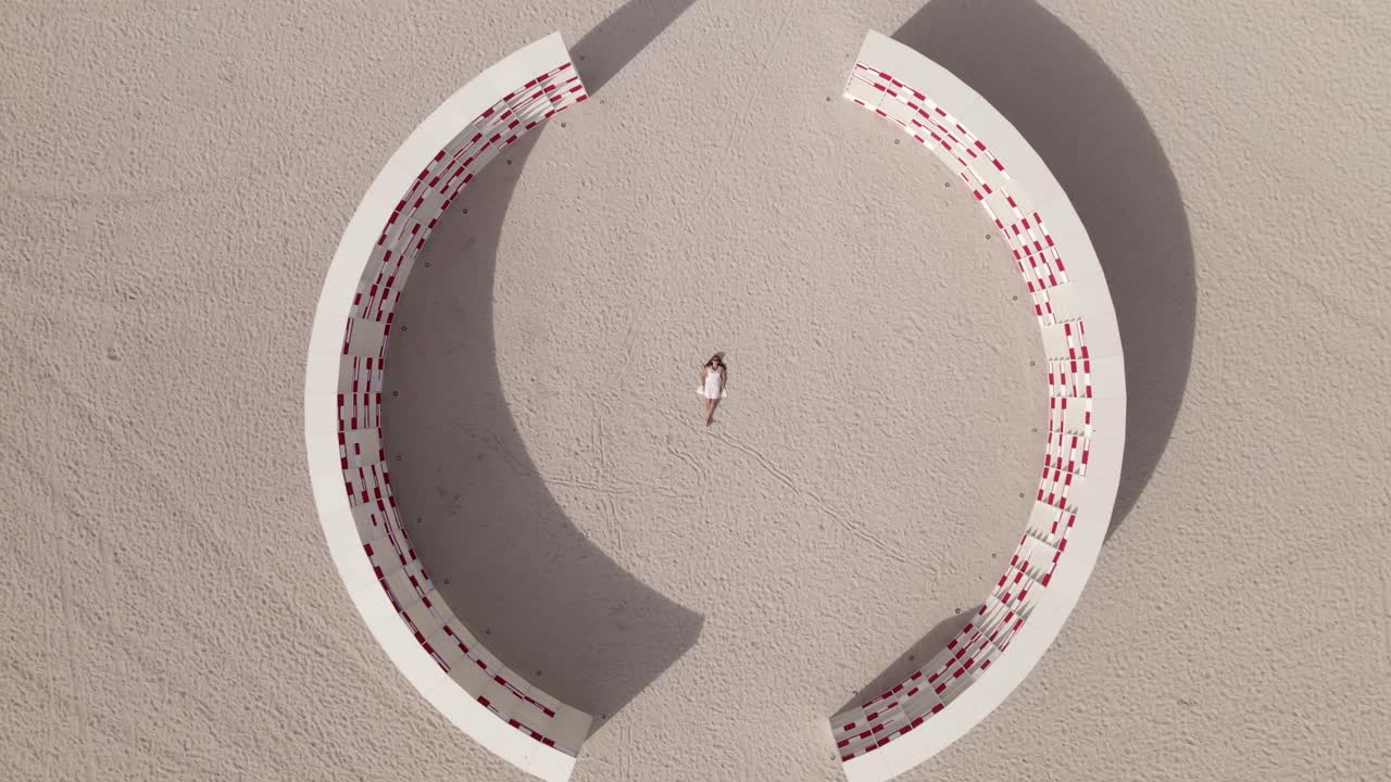 ascendente vertical aérea de la mujer y la instalación de arte en la playa de miami