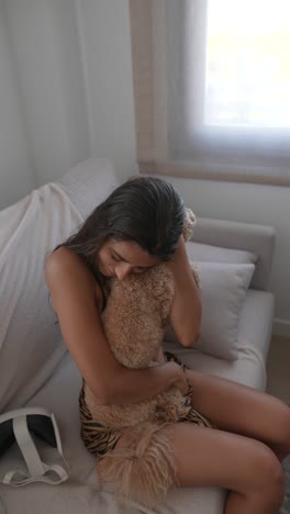 woman hugging a dog on a sofa