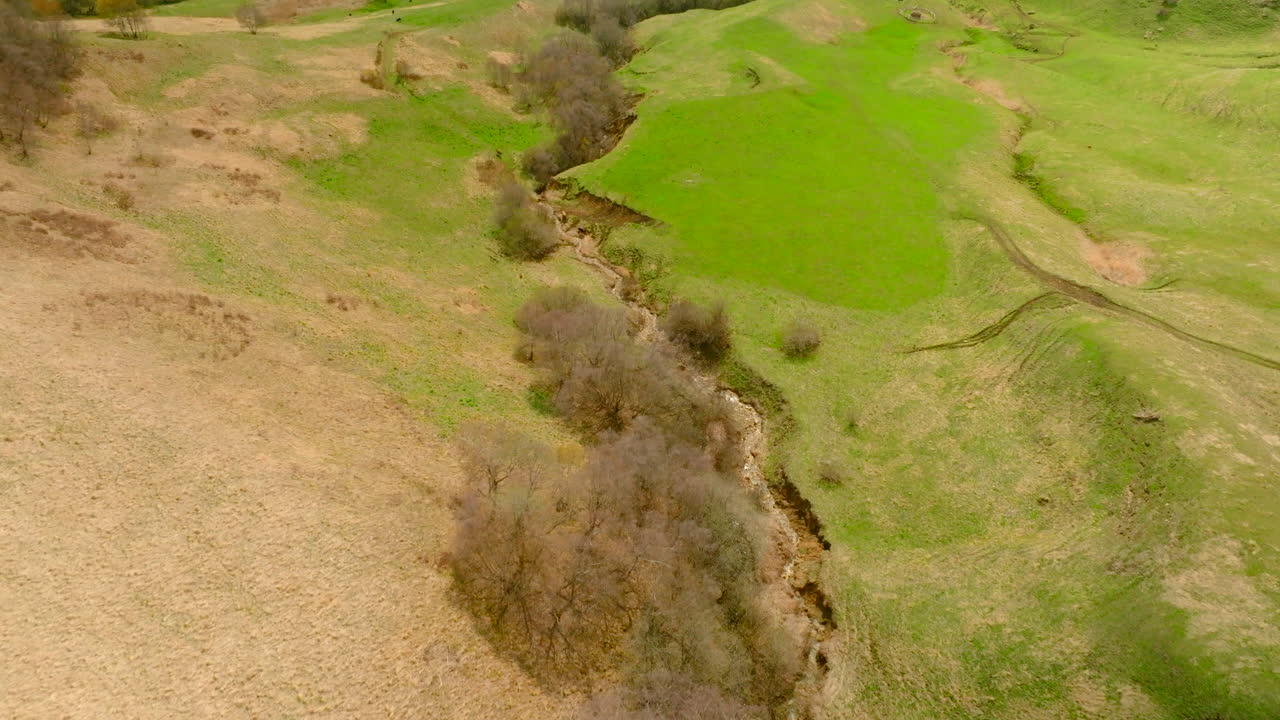 vista aérea de un valle montañoso con exuberantes pastos verdes
