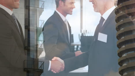 digital composition of two caucasian businessmen shaking hands against tall buildings