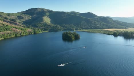 tomada de avión no tripulado de spirit lake, idaho con barcos en el lago cerca de la puesta del sol