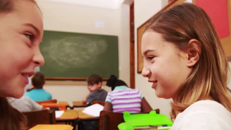 alumnos susurrando secretos durante la clase
