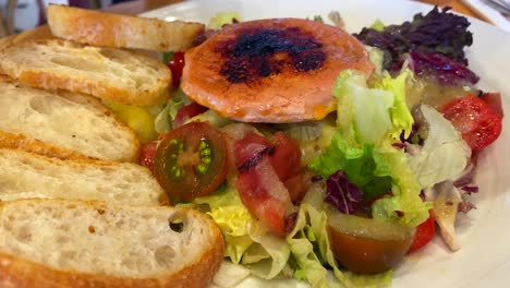 Comiendo-Una-Clásica-Ensalada-De-Queso-De-Cabra-Con-Tostadas,-Ensalada-Tradicional-Española,-Comida-Sabrosa-En-Marbella-España,-Toma-De-4k