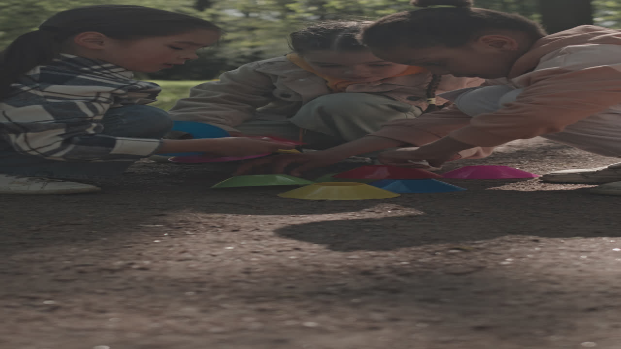 Little Girls Playing with Plastic Toys in Park