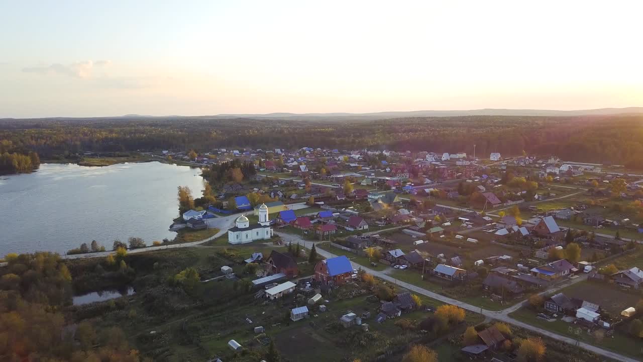 해가 지고 있는 호수  에 있는 러시아 마을 의 공중 사진