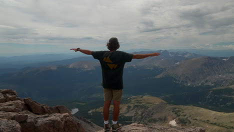 Cinematic-man-person-at-the-top-of-Rocky-Mountain-National-Park-Colorado-Denver-Boulder-Estes-Park-14er-Longs-Peak-looking-out-to-Indian-Peaks-sunny-cloudy-late-summer-dramatic-landscape-still