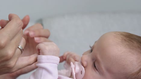 Nahaufnahme-Eines-Süßen-Babys,-Das-Den-Finger-Seiner-Mutter-Hält