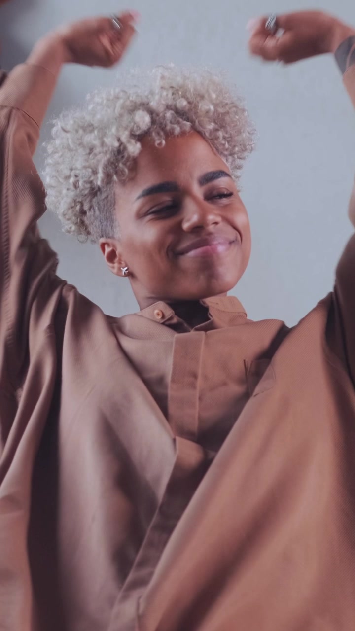 Mulher afro-americana relaxada, recostada e alongando os braços feliz.