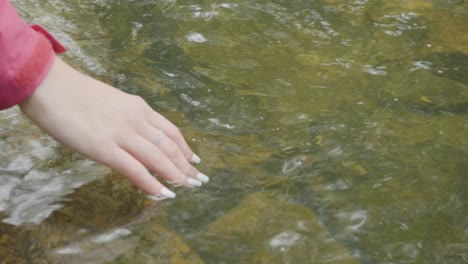 woman touching water in a stream