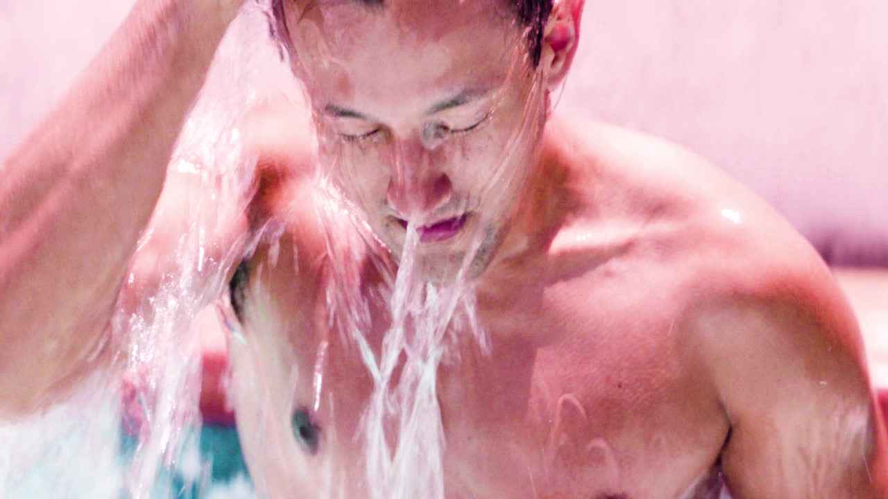 Male coming out from under water in a pool