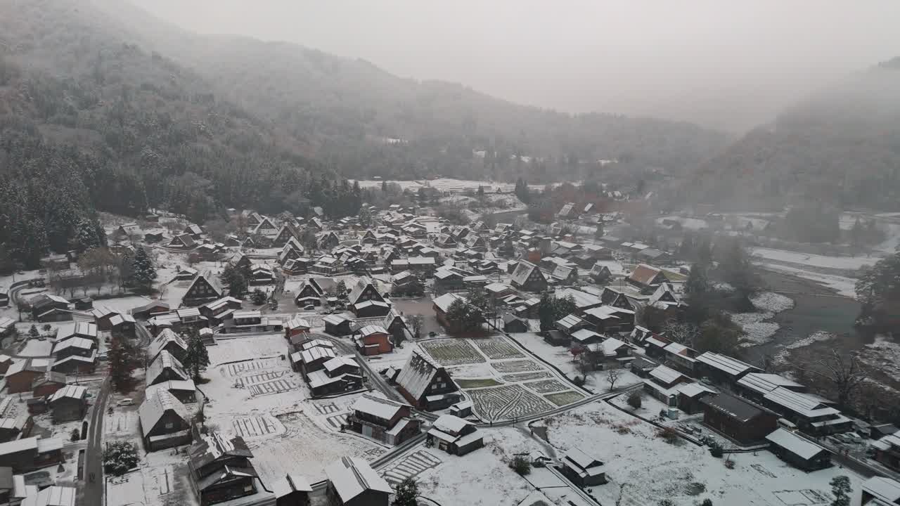 일본 시라카와고 마을에서 눈이 부드럽게 떨어지면서 상징적인 가소-주쿠리 집과 주변 풍경을 는 매혹적인 드론 입니다.
