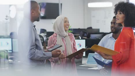 Group-of-diverse-business-people-holding-documents-and-talking-in-office,-slow-motion