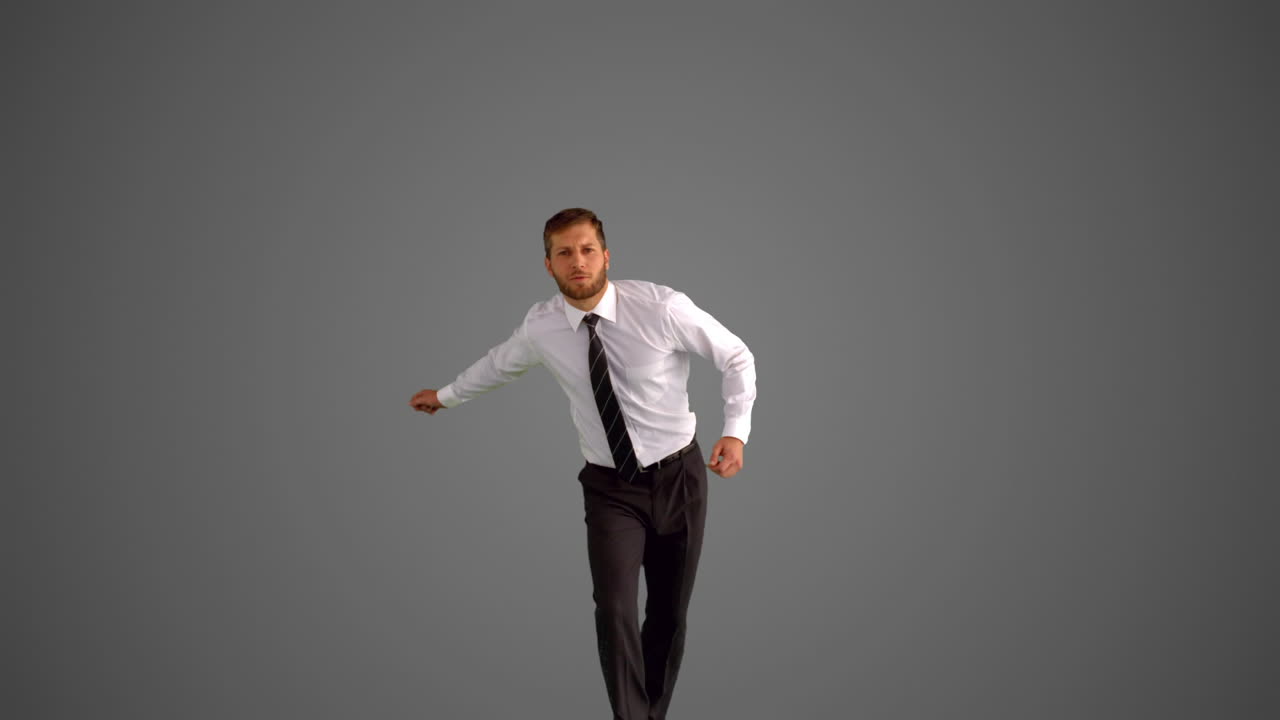 Businessman jumping and clicking heels on grey background