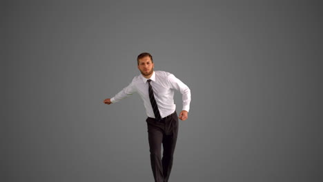 businessman jumping and clicking heels on grey background