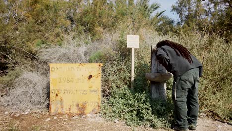 Nature-reserve-guard-drink-water,-Yellow-old-sign,-Deadsea-area-park,-Israel