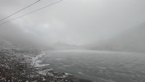 cloud movement over frozen sela lake with snow cap mountains at morning video is taken at sela tawang arunachal pradesh india