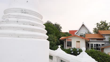 a serene view of wat prayurawongsawat's white pagoda in bangkok, showcasing its intricate architecture and surrounding greenery