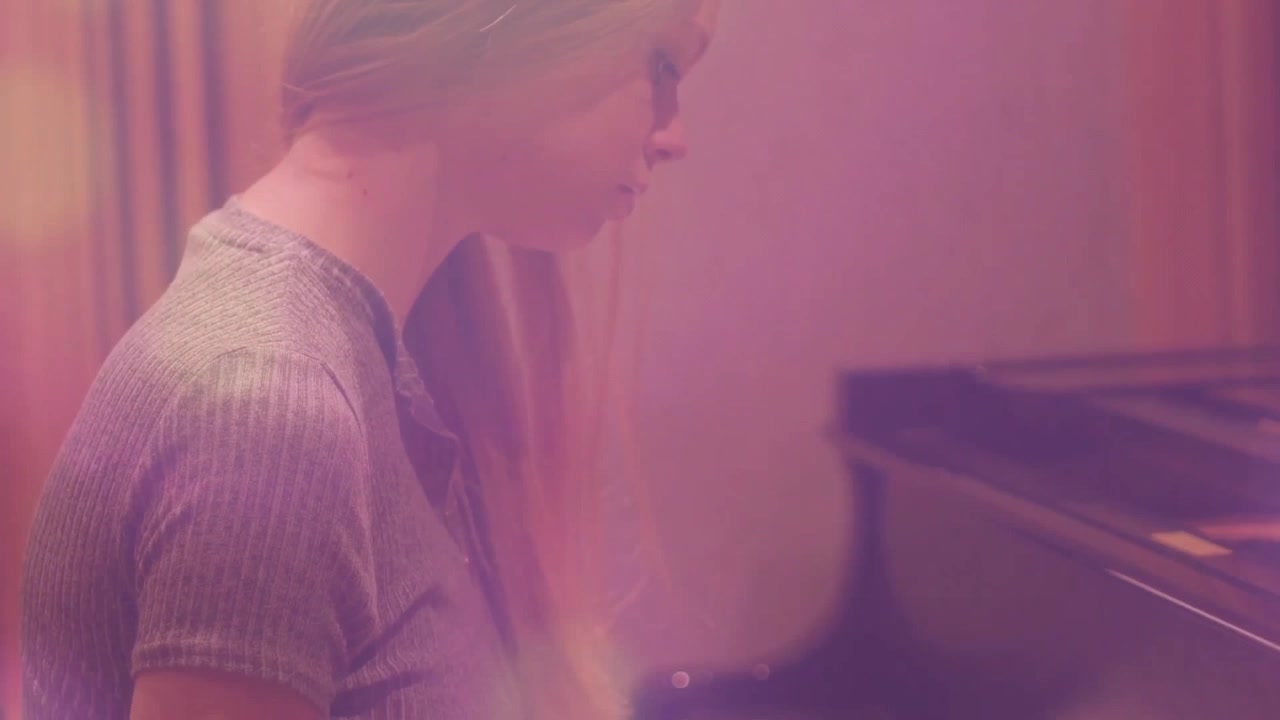 Pianist leaning forward placing fingertips on piano keyboard pressing melody during music rehearsal