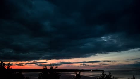 dark clouds passing over a sunset