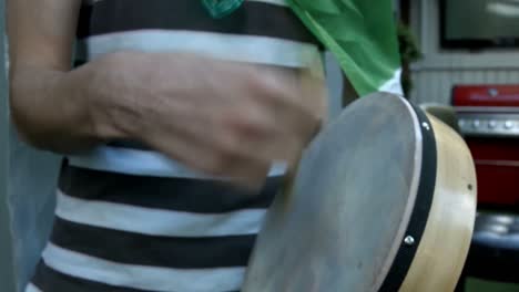 mid section of man playing bodhran