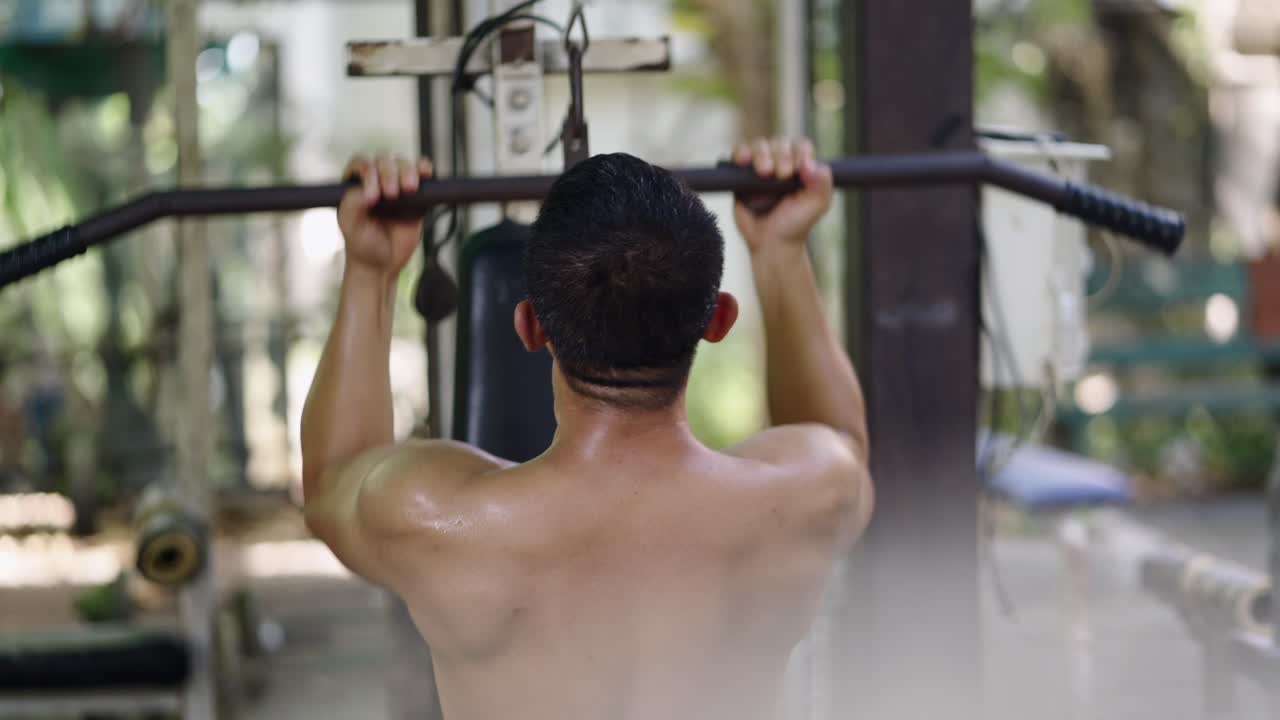 Shirtless man exercising at an outdoor gym