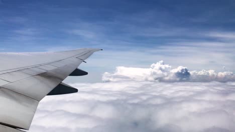 POV-Flugzeug-Mit-Blick-Auf-Schöne,-Flauschige-Wolken-Und-Den-Klaren-Blauen-Himmel-Mit-Flügel-Und-Turbinen-Des-Flugzeugs-Während-Eines-Fluges