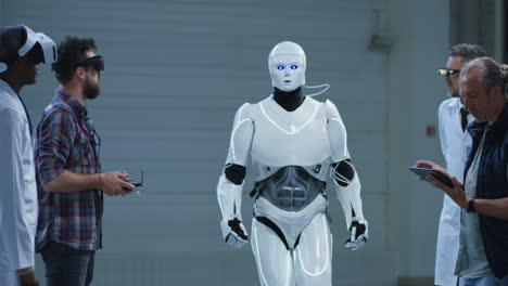 scientists and engineers observing a robot in a manufacturing facility