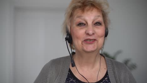 Happy-old-senior-woman-grandmothertalking-to-web-cam-video-conference-calling-enjoying-social-distance-party,-virtual-family-online-chat-meeting-at-home,-webcam-view.