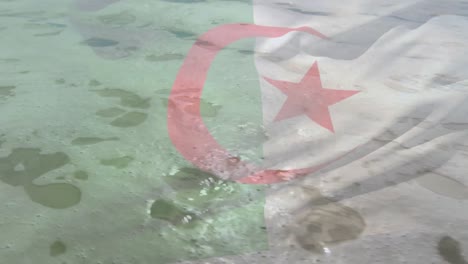 Digitale-Komposition-Der-Algerischen-Flagge,-Die-Vor-Der-Luftaufnahme-Der-Wellen-Im-Meer-Weht