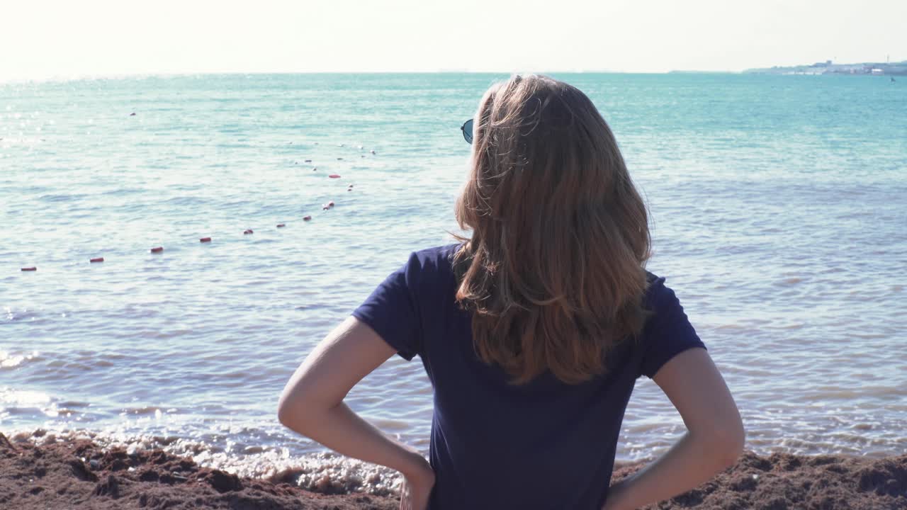 바다를 바라보는 해변에 있는 여자