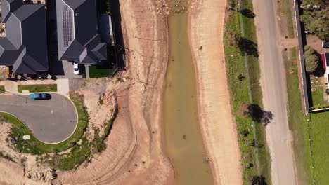 drone shot flying over a dry creek in a new residential housing development in buckland park, south australia